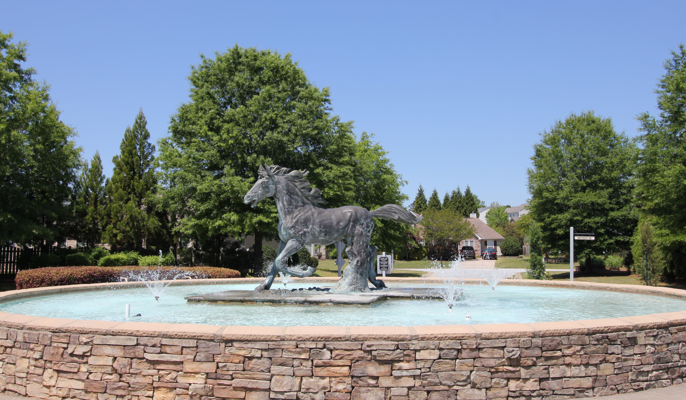 Horse statue in a roundabout water feature of a subdivision on a website about Travelers Rest SC real estate in the upstate of South Carolina.